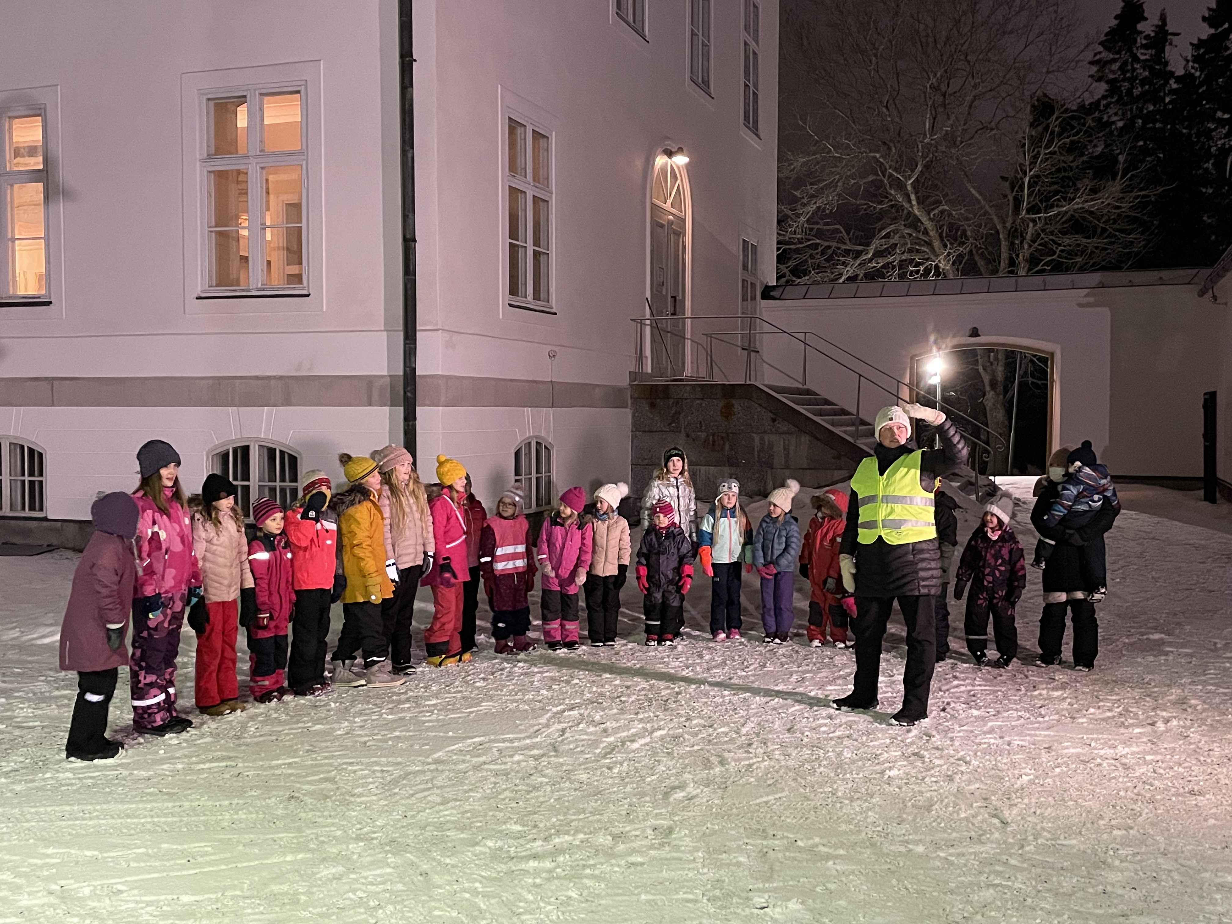 Barnkören sjunger utanför Korsholms kyrka med kantor Susanne Westerlund