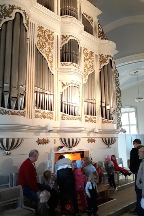 Barnfamiljer på besök på orgelläktaren i Korsholms kyrka