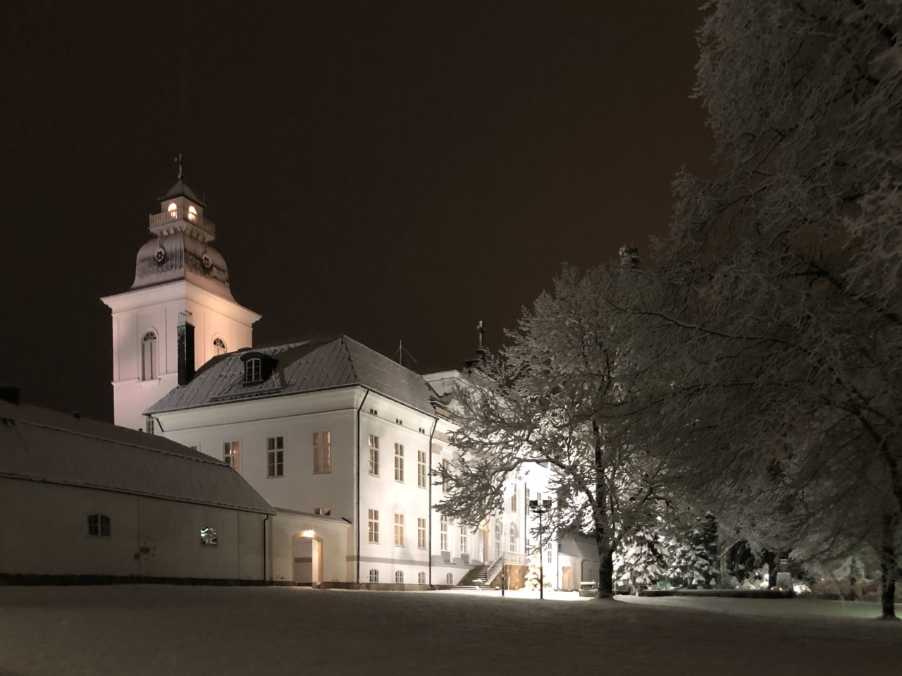 Julbön för små och stora via nätet Korsholms kyrka i kvällsbelysning med snö på marken